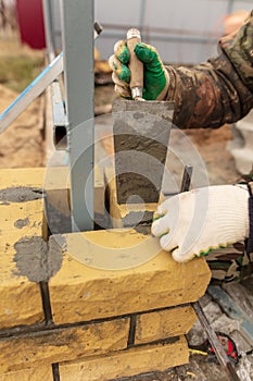 Man builds a brick wall at a construction site