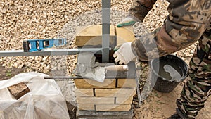 Man builds a brick wall at a construction site