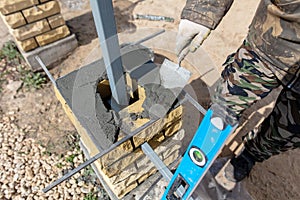 Man builds a brick wall at a construction site