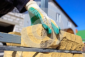 Man builds a brick wall at a construction site