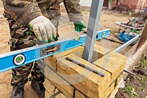 Man builds a brick wall at a construction site