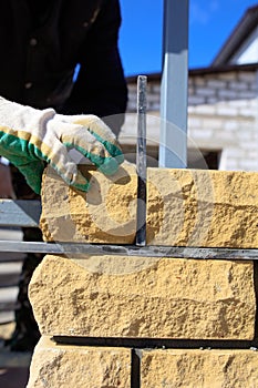 Man builds a brick wall at a construction site