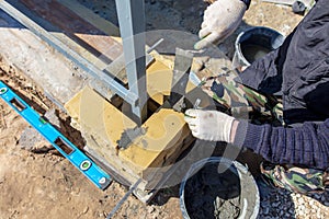 Man builds a brick wall at a construction site