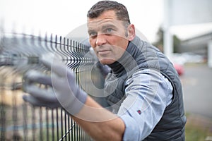 man builds metal fence