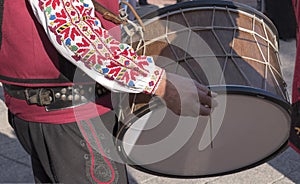 Man in Bulgarian national, traditional costume plays folk ethnic drum - tupan during wine festival in Plovdiv, Bulgaria