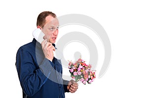 Man with bunch of flowers calling with big toy phone in front of white background