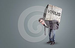 Man burdened by a stone labeled with VIRUS photo