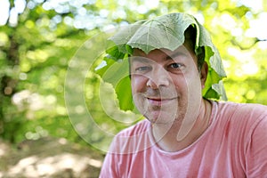 Man with burdock leaf on his head