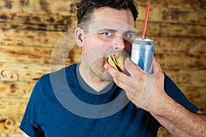 Man with burger and can of pop drink