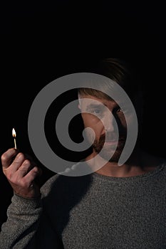man with burning match looking at