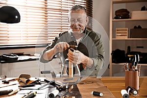 Man burnishing edges of leather belt