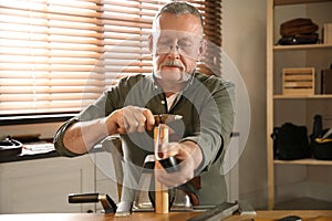 Man burnishing edges of leather belt photo