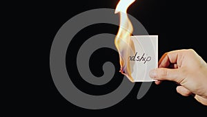 Man burns a paper with the inscription Friendship