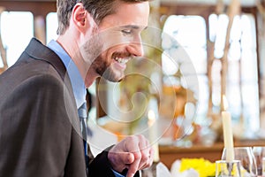 Man on business lunch checking mails on phone