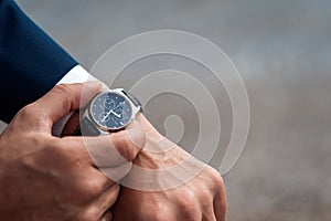 Business suit checking a wrist watch on his hand on background  sea