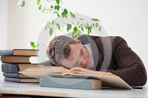 A man in a business suit fell asleep at a desk