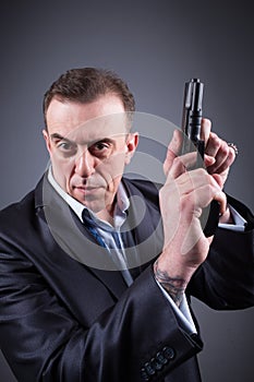 Man in a business suit with a gun