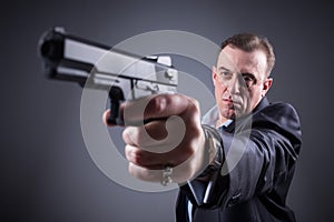 Man in a business suit with a gun