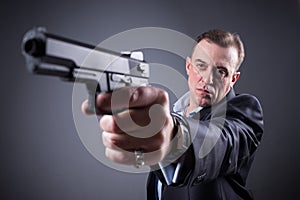 Man in business suit with a gun