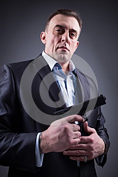 Man in business suit with a gun