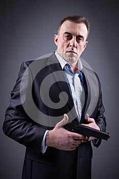 Man in business suit with a gun
