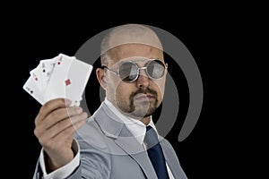 Man in business suit holding 4 aces poker playing cards in his hand