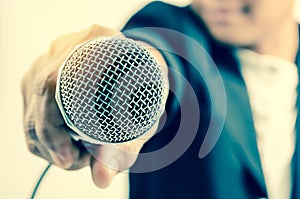 Man in business suit holding a microphone conducting a business