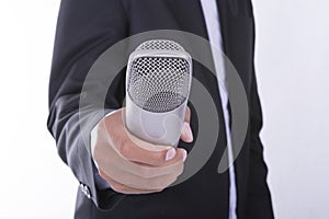 Man in business suit holding microphone - interview concept