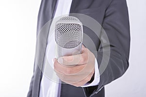 Man in business suit holding microphone - interview concept