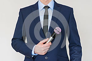 Man in business suit holding a microphone