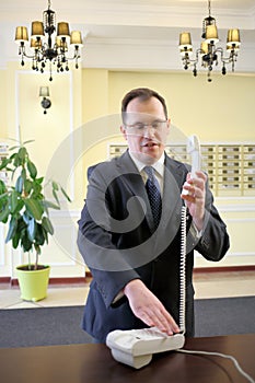 Man in a business suit holding a phone and dials photo