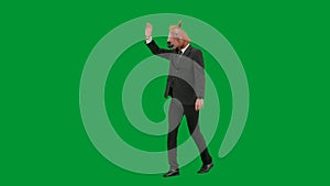 Man in business suit with horse head mask on green studio background. Businessman walking and waving hello. Concept of