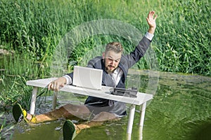 Man in a business suit on the nature in a swamp