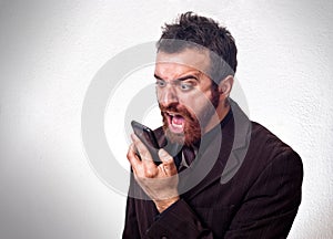 Man in business suit shouting into his mobile phone