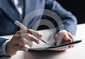 Man in business suit sitting at desk with tablet