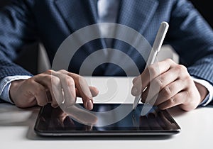 Man in business suit using tablet computer.
