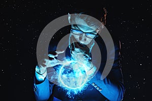 Man businessman holding hands over a blue glowing plasma sphere. Magic prediction and foresight in business and Finance