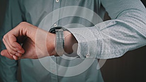 Man Businessman in a Shirt Looks at His Wrist Watch