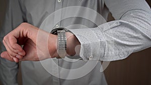 Man Businessman in a Shirt Looks at His Wrist Watch