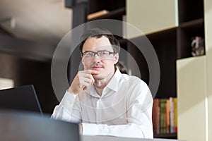 Man businessman working in office or at home at table on laptop. business portrait pensive thinking  man