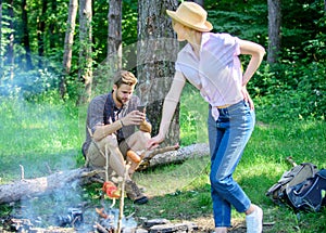 Man busy with smartphone while girl roasting food over fire. Family picnic nature background. Even at vacation he stay