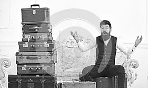 Man, butler with beard and mustache delivers luggage, luxury white interior background. Macho elegant on surprised face