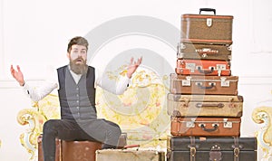 Man, butler with beard and mustache delivers luggage, luxury white interior background. Macho elegant on surprised face