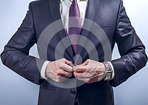 Man buttoning dark jacket