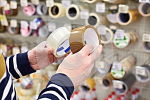 Man buyer chooses adhesive duct tape in store