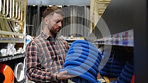 A man buyer chooses hose for washing machines or dishwashers