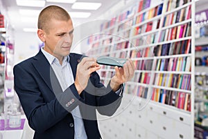 Man buyer choosing phone at the multimedia store