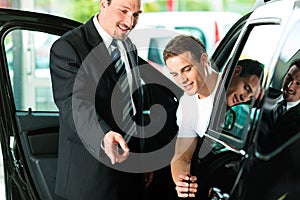 Man buying car from salespersonv