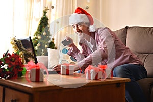 Man buying christmas gifts online at home with card