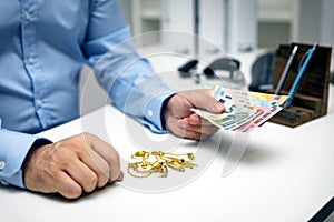 Man buying gold jewellry, pawn shop and euro photo